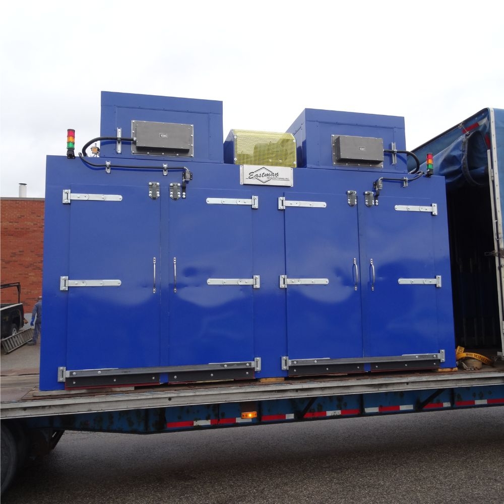 Blue four-door oven loaded on a flatbed trailer for delivery from an industrial oven manufacturer